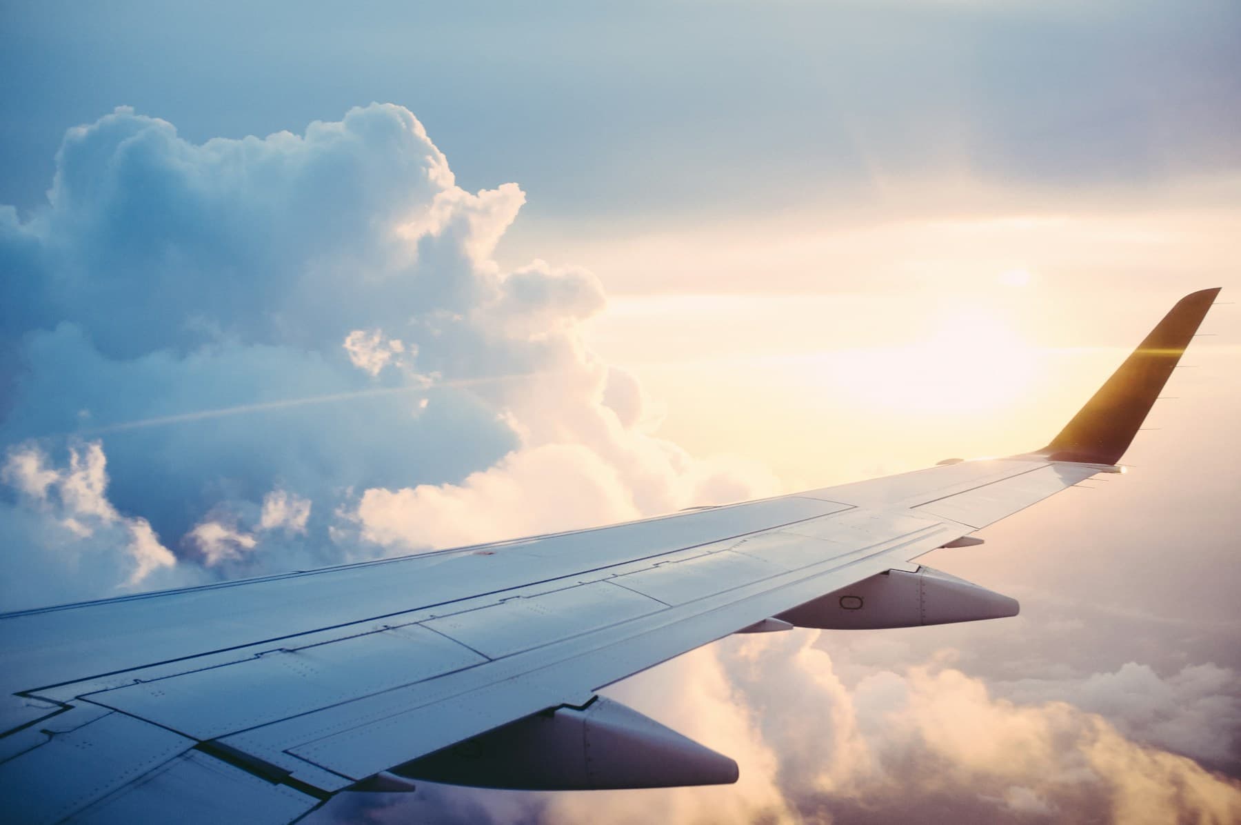 An airplane wing above clouds